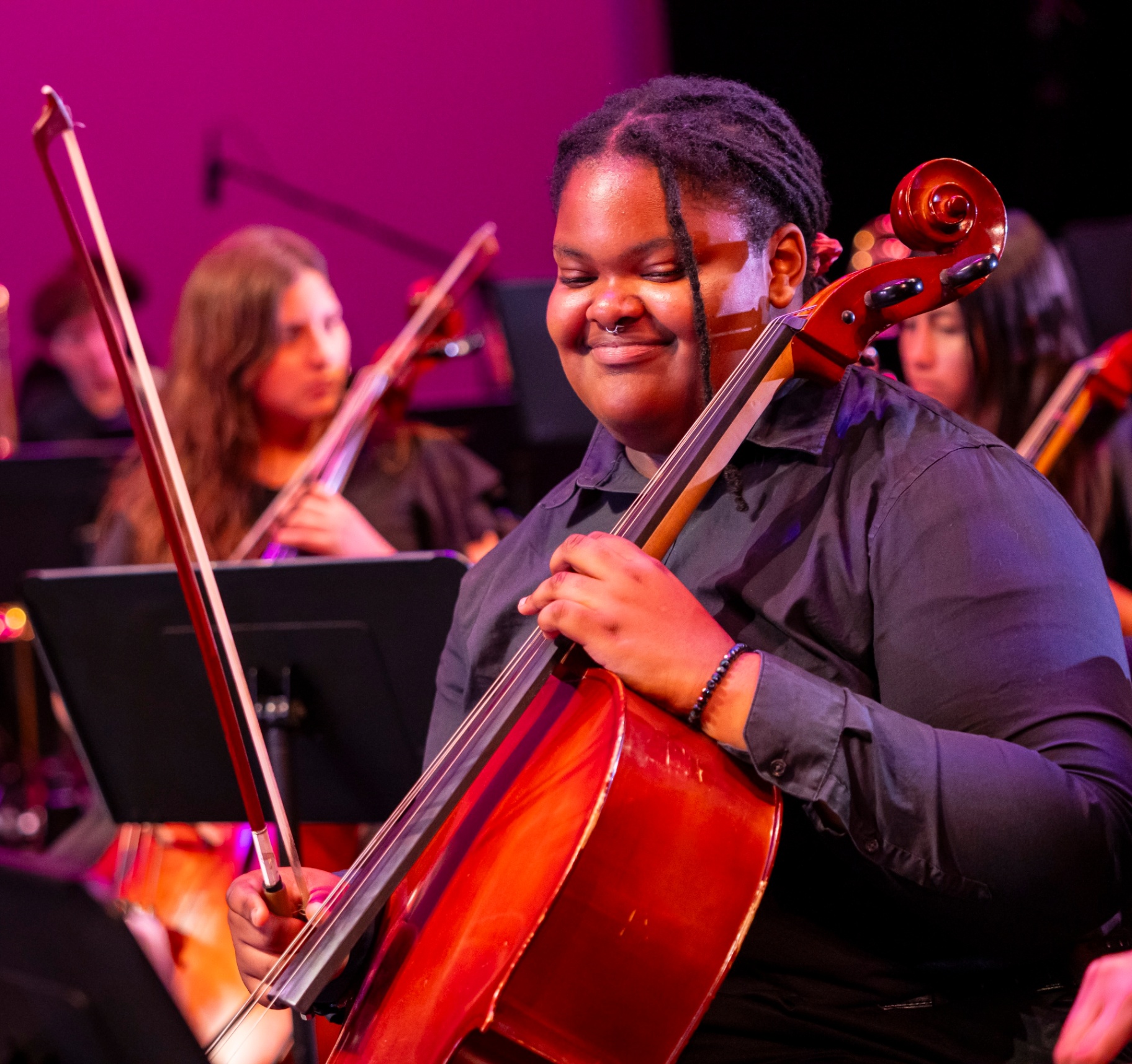 NXT cellist Harmoni Warren smiling while performing